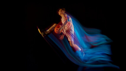 Basketball player flying midair with ball and blue motion streaks showing athletic power. Concept of personal growth, sports education, health promotion, and inspiring freedom style.