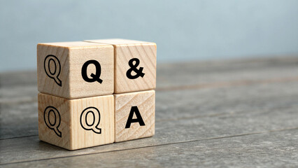 A single wooden cube is placed to the centre, visible face of cube, there is a bold black question mark symbol