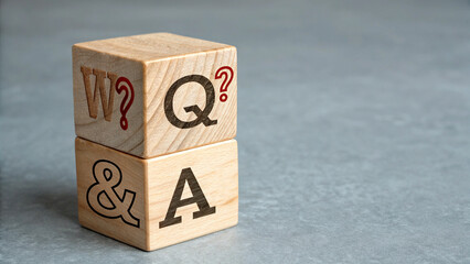 A single wooden cube is placed to the centre, visible face of the cube, there is bold black question mark symbol