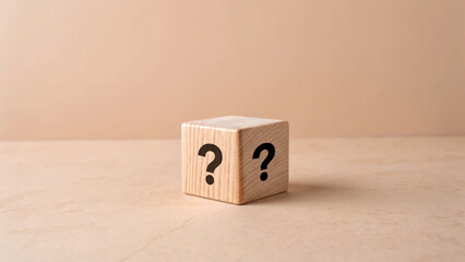 Single wooden cube is placed to the centre, visible face of the cube, there is bold black question mark symbol