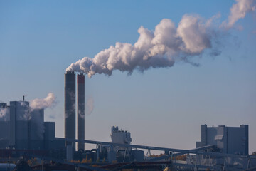 Smoke from the factory chimneys of a heating plant in the city. A power plant running on fuel oil or natural gas. Air pollution. Chimneys, ecology, heating season concept