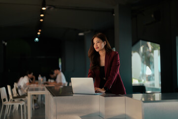 Asian businesswoman working on laptop at standing desk