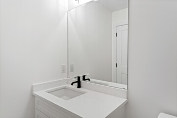 Bathroom with a white sink and a black faucet