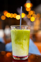 Iced Matcha Latte with Bright Bokeh Lights in Café
