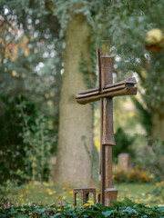 Herbst im Park mit leuchtenden Farben bei Regenwetter, am Grab mit Eisenkreuz