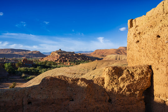 Sunlit ancient desert village with clay buildings and clear blue sky. Ait Benhaddou. Morocco