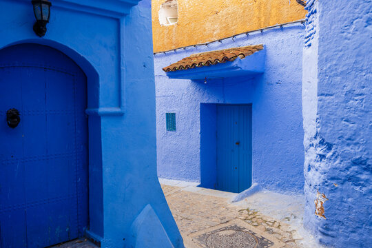 Vibrant blue alley in a Moroccan medina with traditional architecture and doors. Chefchaouen, Morocco