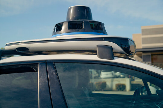 Self-driving car with sensor equipment mounted on the roof under a clear blue sky. California, USA