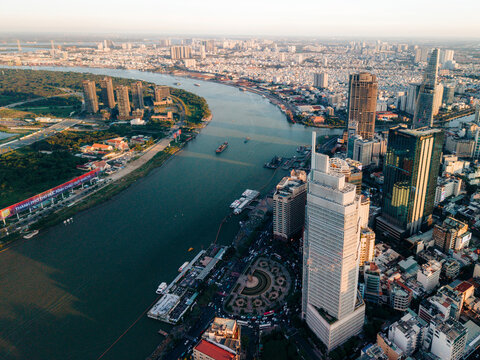 Aerial view of a bustling city with skyscrapers and a winding river at sunset. Ho Chi Minh City, Vietnam