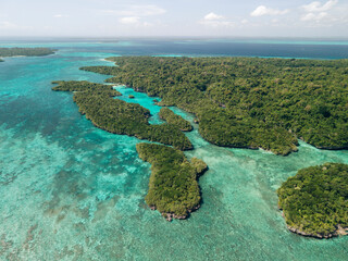 Aerial view of lush green islands surrounded by turquoise blue ocean waters. Pulau Bair or Bair Island in Kei Kecil, Southeast Maluku Regency, Indonesia
