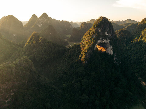 Majestic mountain landscape with lush greenery and sunlight illuminating a rocky arch. God?s Eye Mountain, Cao Chuong, Tr˘ng Kh&middot;nh District, Cao Bang, Vietnam