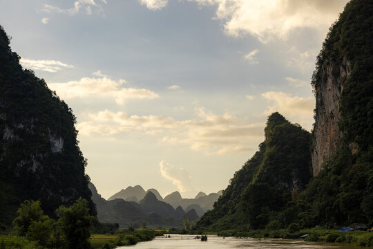 Scenic river valley framed by lush green mountains under a partly cloudy sky. Phong Nam, Tr˘ng Kh&middot;nh District, Cao Bang, Vietnam