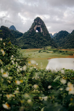 Lush green mountain landscape with a unique arch atop a peak, surrounded by lush vegetation. God?s Eye Mountain, Cao Chuong, Tr˘ng Kh&middot;nh District, Cao Bang, Vietnam