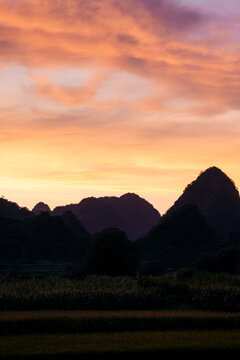 Stunning sunset over distant mountain silhouettes with a vibrant sky. Phong Nam, Tr˘ng Kh&middot;nh District, Cao Bang, Vietnam
