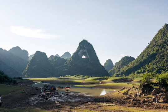 Scenic view of a tranquil mountain landscape with boats and lush greenery under a blue sky. God?s Eye Mountain, Cao Chuong, Tr˘ng Kh&middot;nh District, Cao Bang, Vietnam