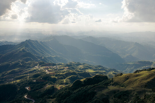 Sunlit mountains and valleys under a cloudy sky with rays of light streaming down. Loc B&Iuml;nh District, Lang Son, Vietnam