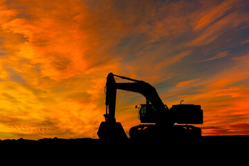 Silhouette Excavator Against Vibrant Orange