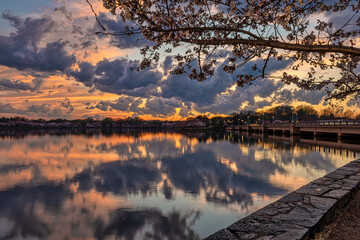 Tranquil lake scene with vibrant sunset and dramatic clouds reflecting in the water. Washington DC, WA, USA