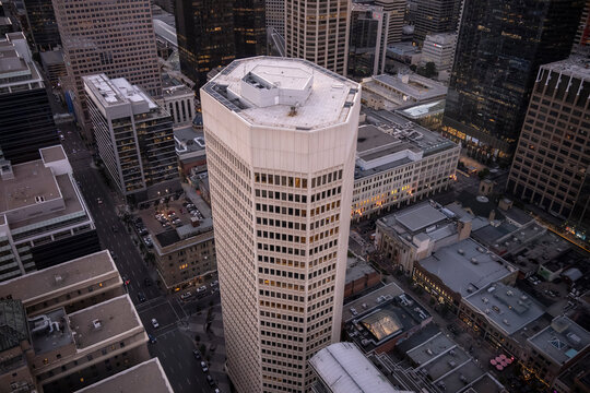Aerial view of a cityscape with a prominent hexagonal skyscraper surrounded by other tall buildings. Calgary, Alberta, Canada