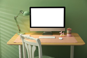 Stylish workplace with computer and pink mat on desk in office