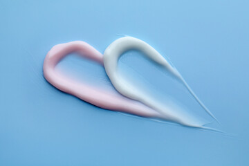 Samples of different cosmetic products on light blue background, flat lay