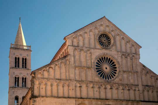 A historic stone cathedral with a bell tower under a clear blue sky. Zadar, Croatia