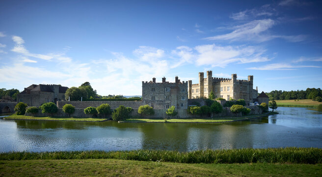 Leeds Castle, Historic castle with lush greenery and wide moat under a clear blue sky. Kent, UK