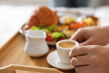 Man having breakfast in bed, closeup. Hotel room service