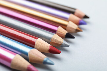 Fototapeta premium Different eye pencils on light background, closeup