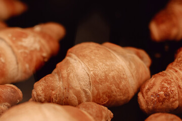 Delicious traditional croissants on the cafe counter on black background
