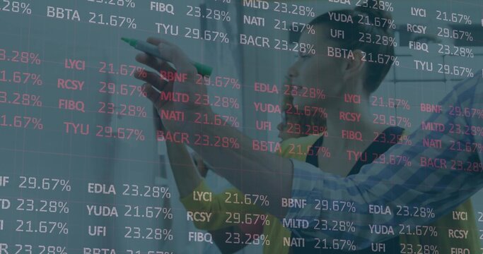 Analyst annotating transparent board in office, with green marker and financial tickers, copy space