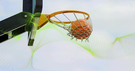 Capturing basketball rim dropping orange basketball through net outdoors, with metal support arm