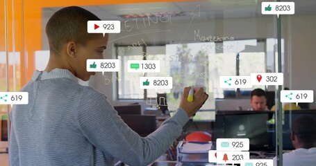 Writing marketing notes with yellow marker on glass board by woman in office, copy space