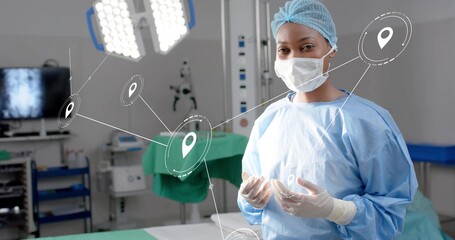 Monitoring surgeon in blue scrubs checking monitor in operating room, with pin icons, copy space