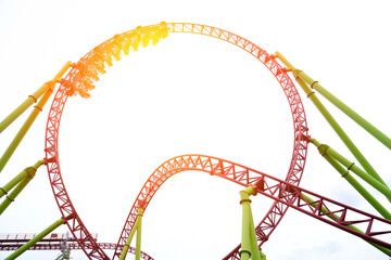 Obraz premium A group of excited riders experiences the rush of a roller coaster at an amusement park. Bright colors and energy fill the scene under a clear sky in the afternoon