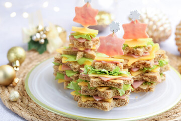 Christmas food. Fir trees made of bread, cheese, ham, lettuce and decor on table, closeup. Bokeh effect