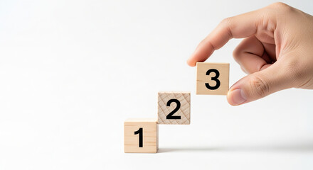 Hand placing numbered wooden blocks to represent a step-by-step process, growth, or a simple counting sequence.