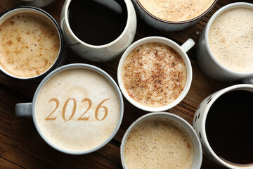 Hello New 2026 Year. Cup of coffee with numbers among others on table, top view