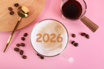 New 2026 Year card with cup of coffee and roasted beans on pink background, top view