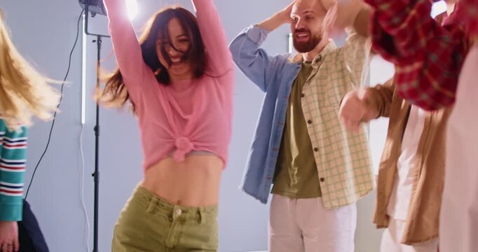 Carefree positive woman posing in circle of friends, dancing together, having fun, shooting themselves on camera, being full of joy and happiness, enjoying loud music. People, entertainment