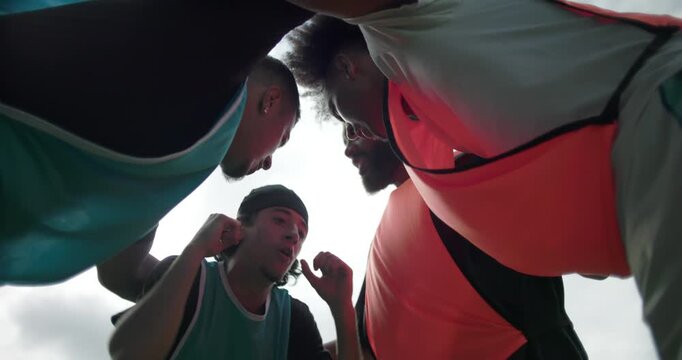 Hispanic friends giving motivational speech and cheering in soccer huddle before match, expressing unity, excitement, energy, and encouragement before friendly outdoor game