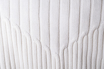 Close-up of a warm, white knit fabric featuring a distinct vertical ribbed pattern (rib stitch). Ideal texture background for winter fashion, cozy designs, or textile concepts