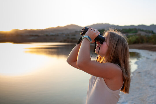 Girl birdwatching with binoculars in Eilat bird park