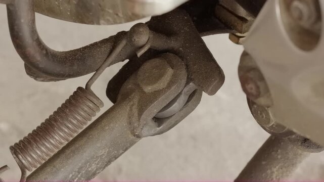 Close-up motorcycle side stand hinge mechanism and spring