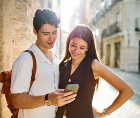 Couple enjoys a sunny day walking together in a charming urban area during late afternoon or tourists visiting a destination  looking at phone map app