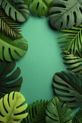 Tropical green leaves border on textured teal background with frame of varied leaf shapes
