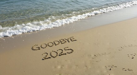 Goodbye 2025 written in sand on a beach with waves approaching