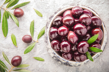 Whole natural black olives in bowl. It's healthy Mediterranean snack.