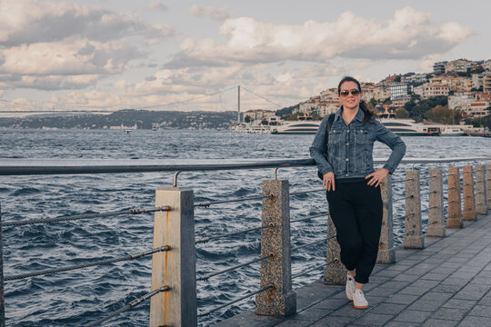 Mujer de mediana edad, de paseo por el estrecho del B&oacute;sforo en Estambul, Turqu&iacute;a. Al fondo el ferry y el puerto. Viajes y turismo.