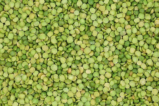 Green, dry split peas background in top view.